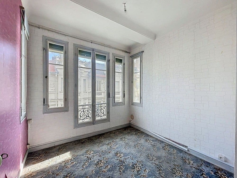 Bedroom with tall windows onto the street, 1-bedroom apartment in the Carré d’Or, Nice