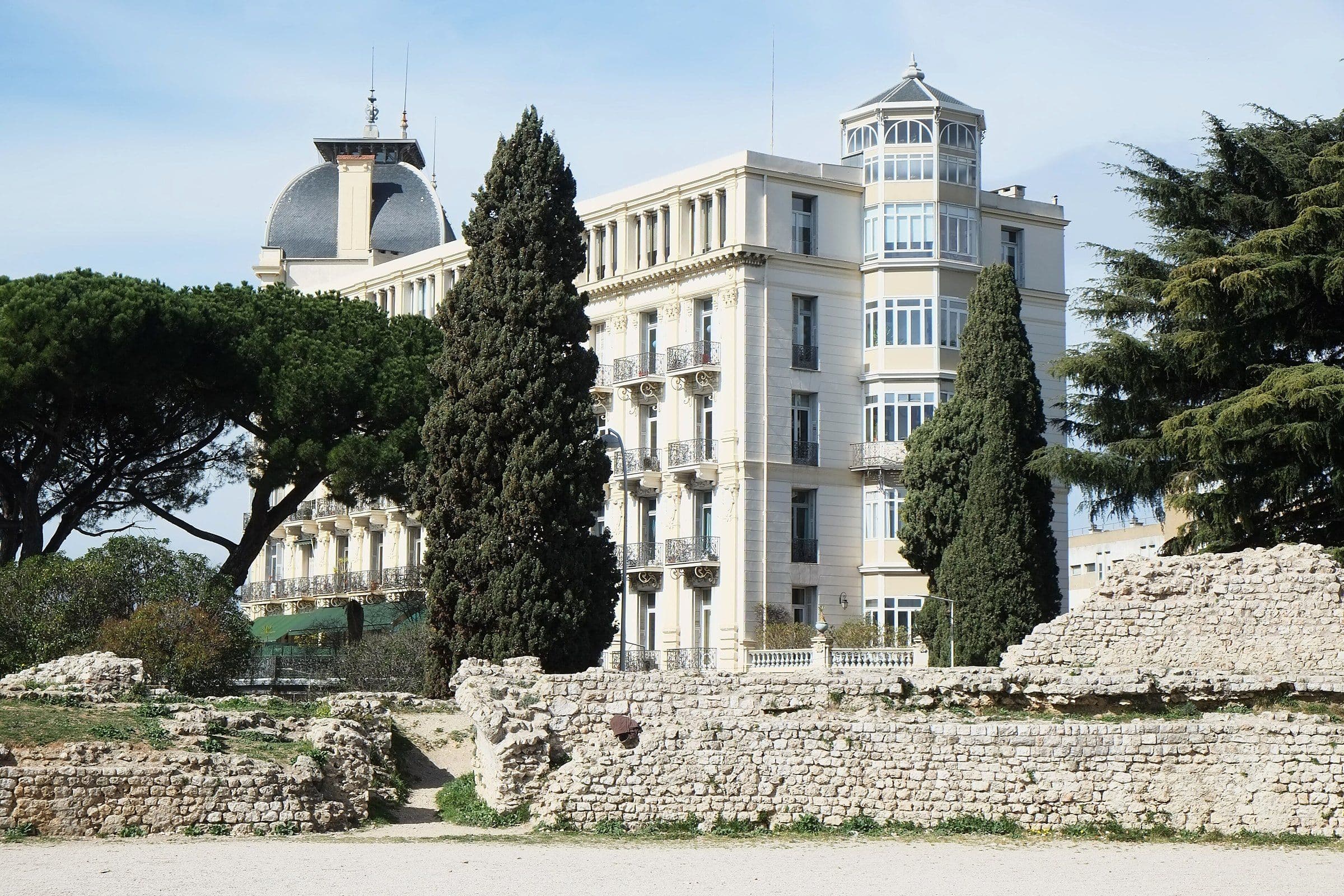 The Belle Époque Régina palace behind the cypresses and Roman ruins of the Parc des Arènes in Cimiez
