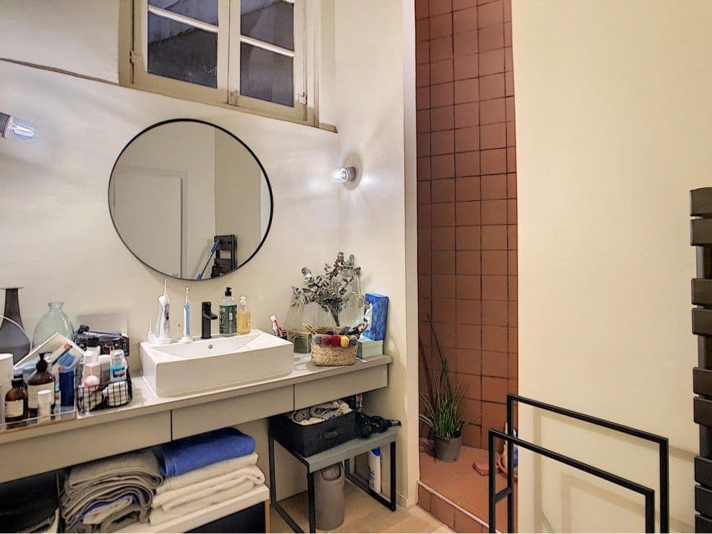 Shower room with vanity, round mirror and terracotta tiled wall, 1-bedroom apartment in the Port, Nice