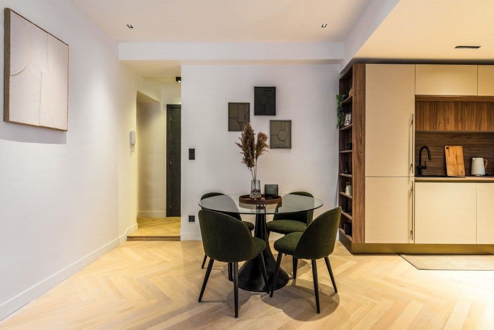 Dining area with round glass table and fitted kitchen, 2-bedroom apartment in the Old Town, Nice