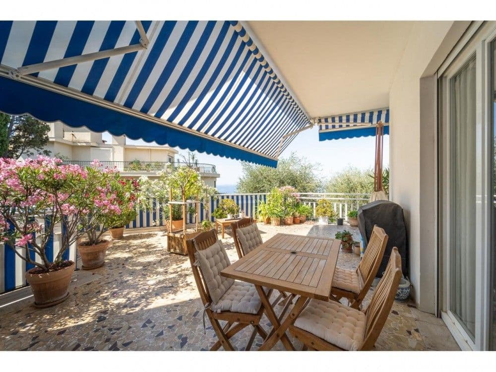 Covered terrace with dining table and flowering plants, 2-bedroom apartment in Mont Boron, Nice