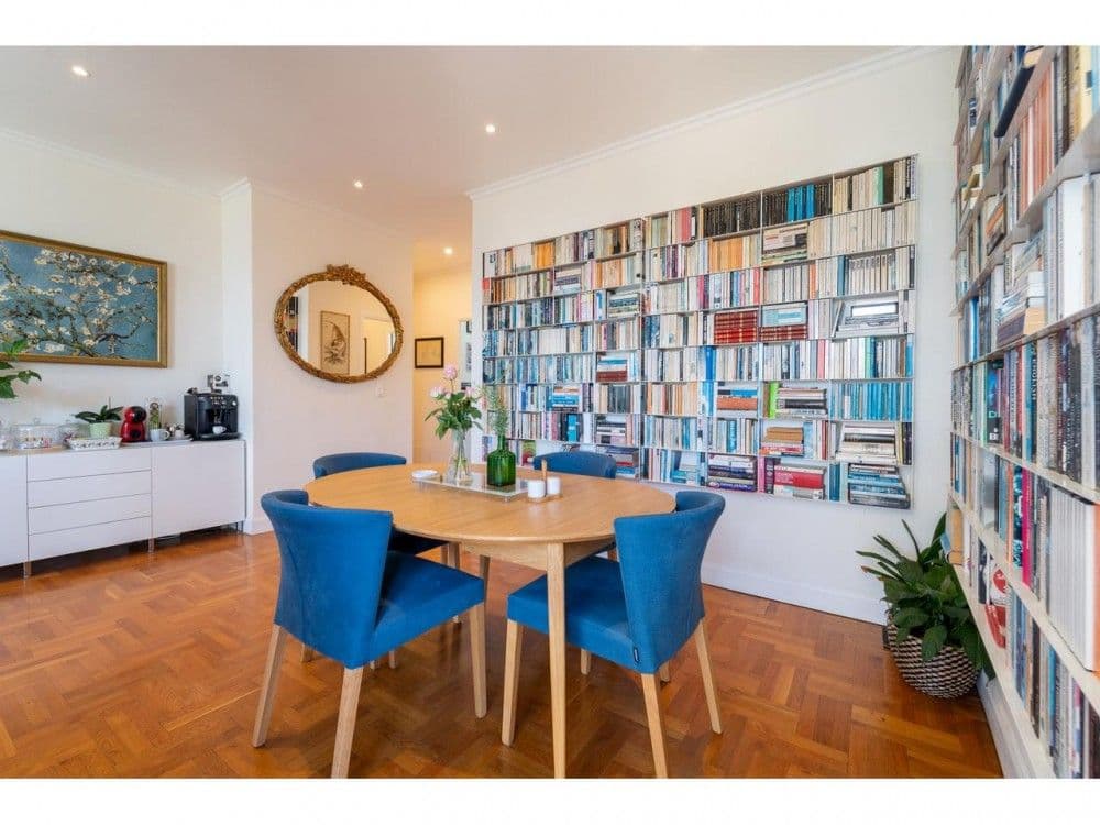 Dining area with blue chairs and wall of bookshelves, 2-bedroom apartment in Mont Boron, Nice