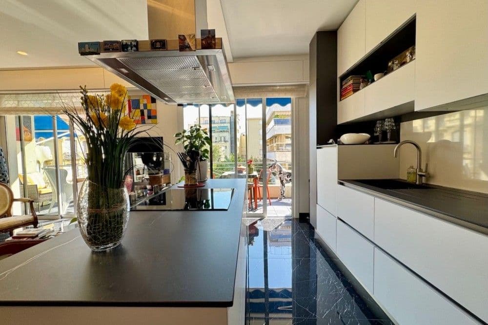 Kitchen island with induction hob and stainless steel hood, 2-bedroom apartment in the Carré d’Or, Nice