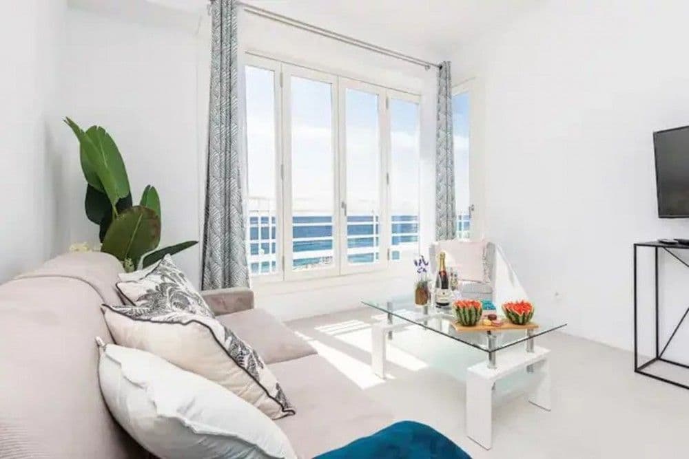 Living room with sofa, glass coffee table and windows facing the sea, 2-bedroom apartment in the Promenade des Anglais, Nice