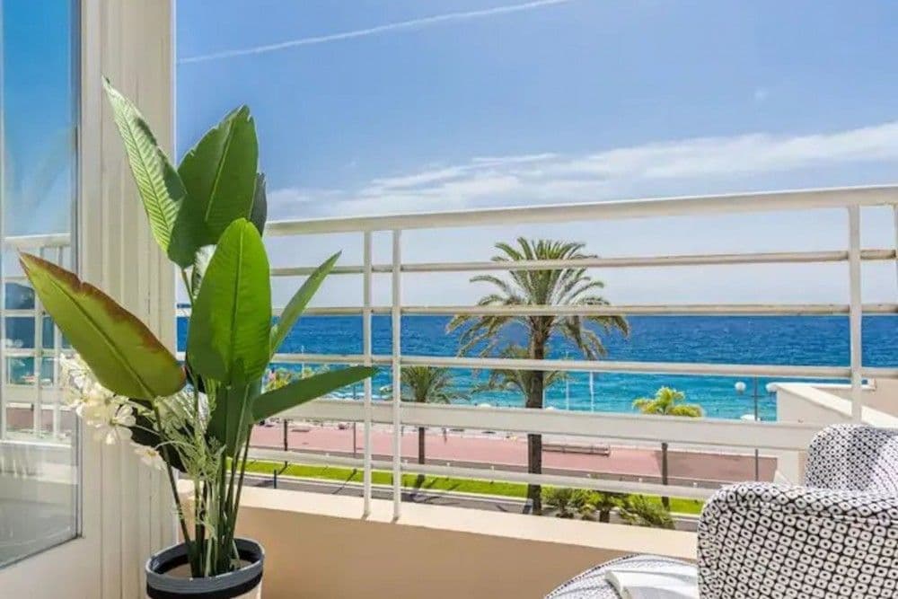 Balcony with armchair and palm trees in front of the sea, 2-bedroom apartment in the Promenade des Anglais, Nice