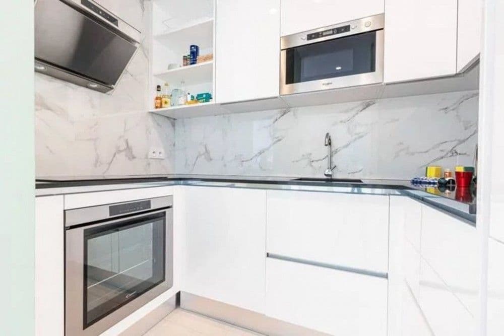 Fitted kitchen with white gloss units and marble-effect splashback, 2-bedroom apartment in the Promenade des Anglais, Nice