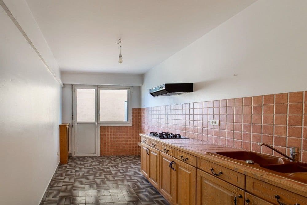 Kitchen with wooden units and door to a service balcony, 2-bedroom apartment in the Port, Nice
