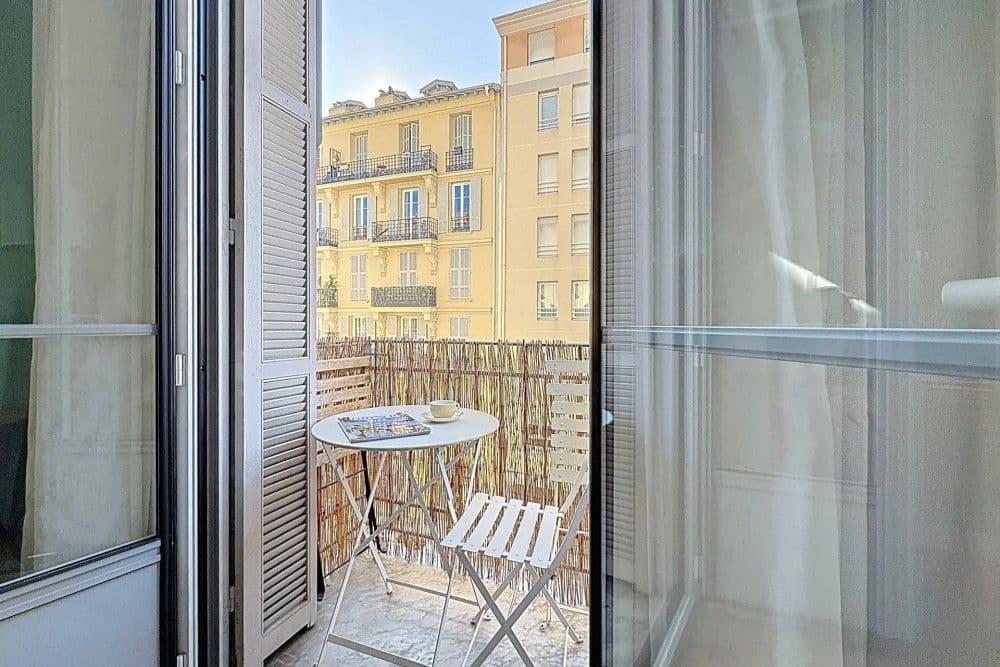 Balcony with bistro set facing ochre façades, 1-bedroom apartment in the Port, Nice