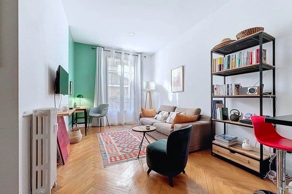 Living room with herringbone parquet, bookshelf and green feature wall, 1-bedroom apartment in the Port, Nice