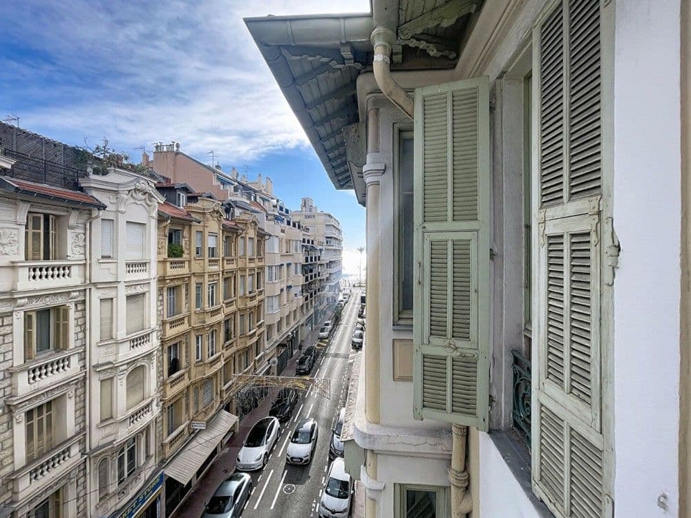 View down the street from a balcony with green shutters, 1-bedroom apartment in the Carré d’Or, Nice