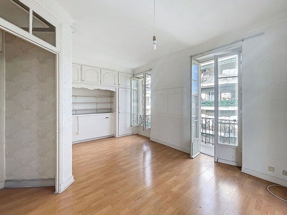 Room with built-in shelving and French windows, 1-bedroom apartment in the Carré d’Or, Nice
