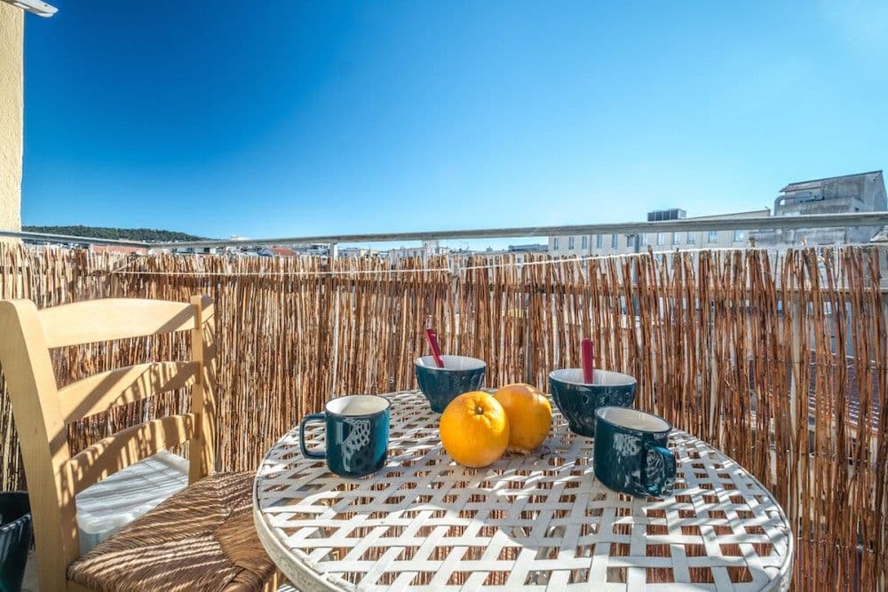 Balcony with breakfast table and reed screen, 1-bedroom apartment in the Carré d’Or, Nice
