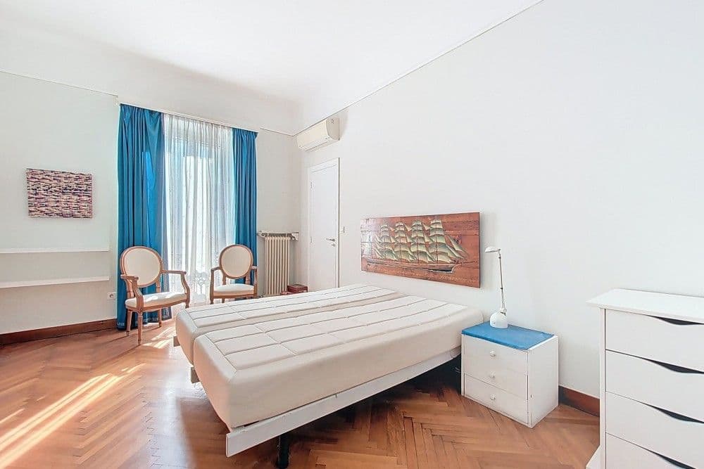 Bedroom with herringbone parquet and blue curtains, 3-bedroom apartment in central Nice