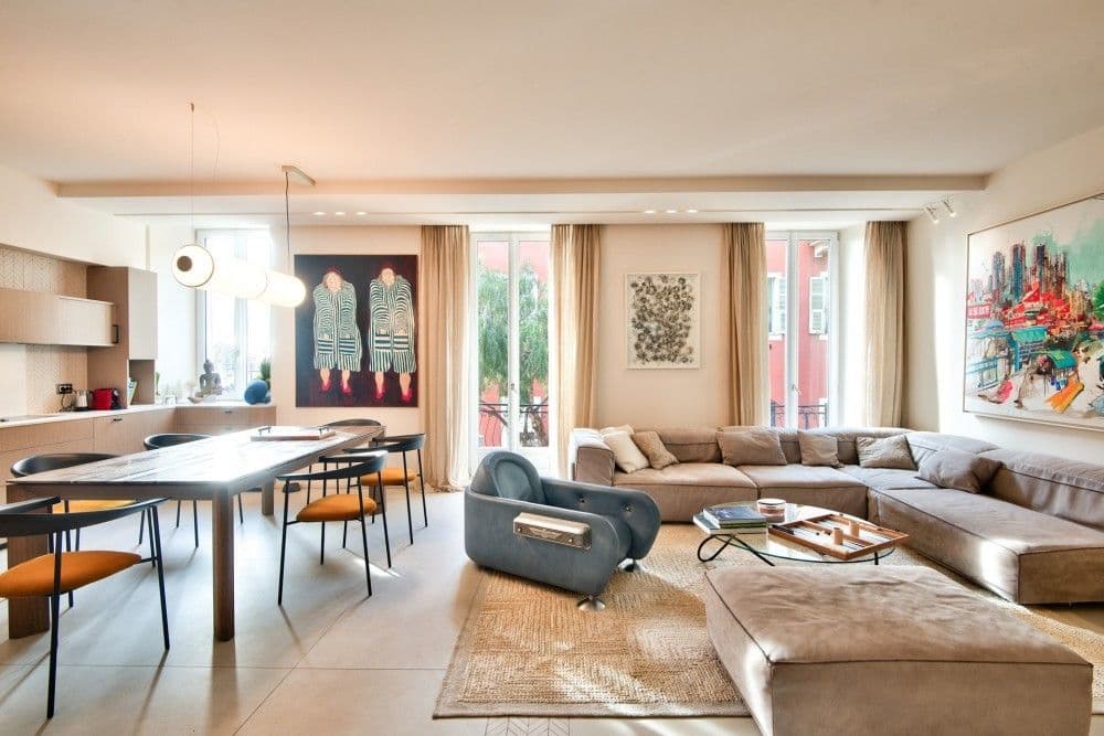 Open-plan living and dining room with designer furniture and tall windows, 2-bedroom apartment in the Port, Nice