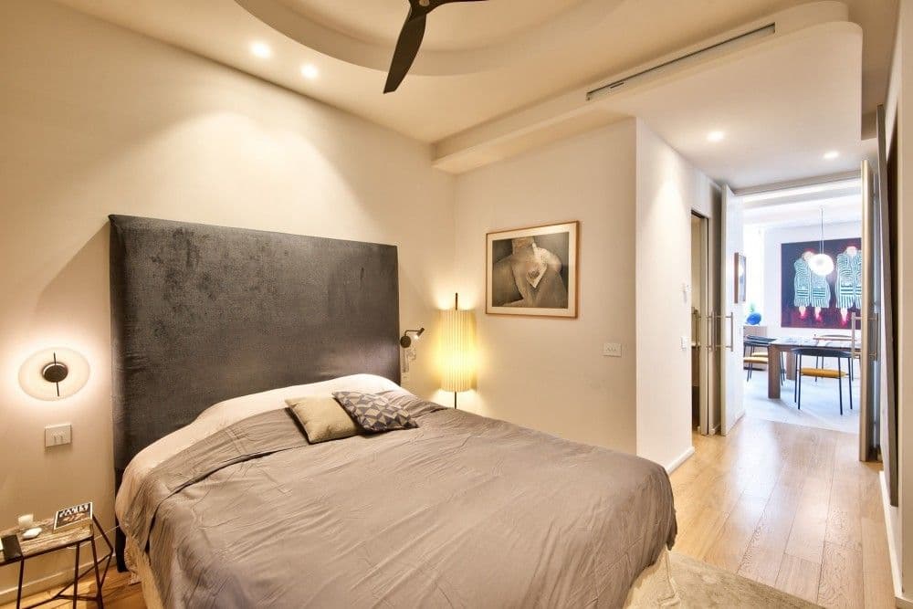 Bedroom with upholstered headboard and doorway to the living room, 2-bedroom apartment in the Port, Nice