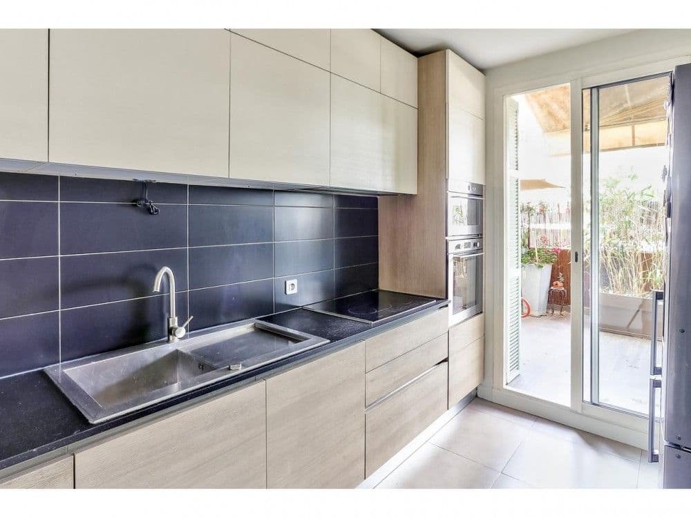 Fitted kitchen with black splashback and glass door to the terrace, 2-bedroom apartment in the Port, Nice