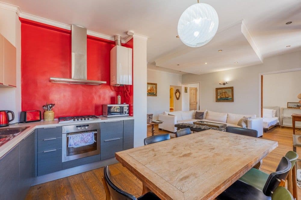 Kitchen with red wall and wooden dining table, 2-bedroom apartment in the Port, Nice