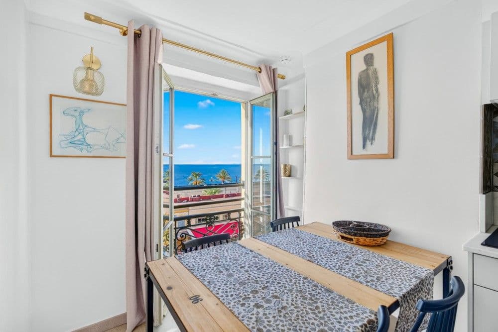Dining table by an open window with a sea view, 2-bedroom apartment in the Old Town, Nice