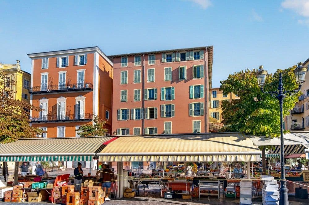 Market stalls in front of the ochre façades of Cours Saleya, 2-bedroom apartment in the Old Town, Nice