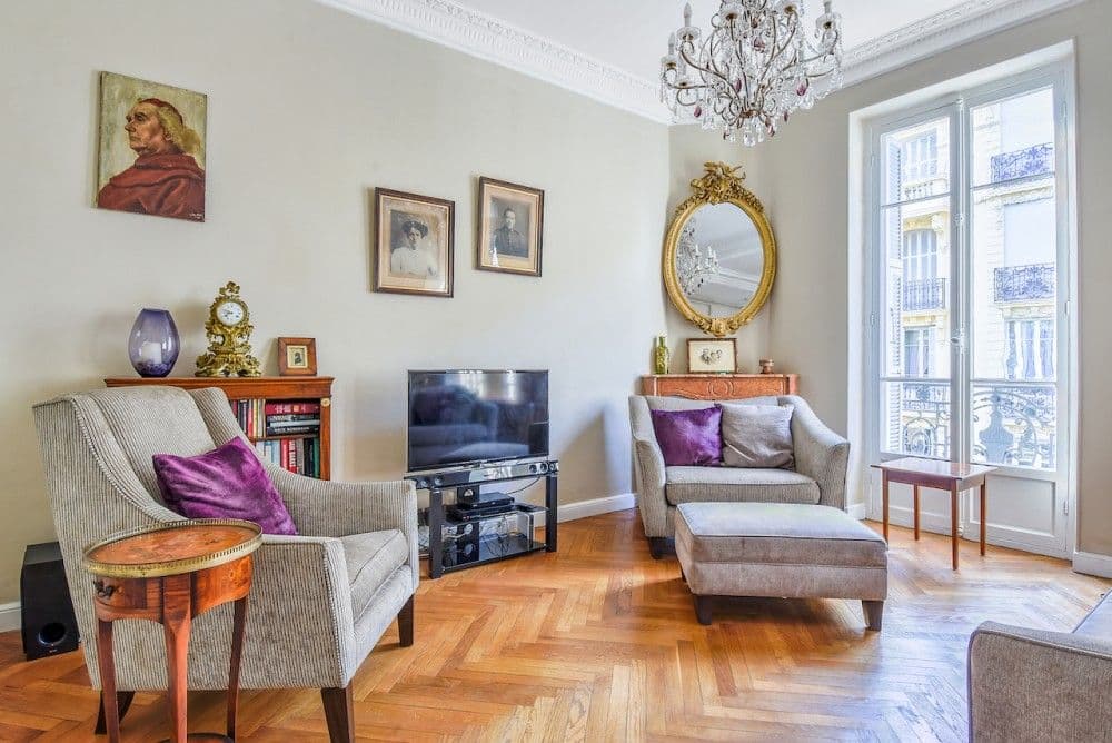 Sitting area with armchairs, gilt mirror and tall windows, 2-bedroom apartment in the Carré d’Or, Nice