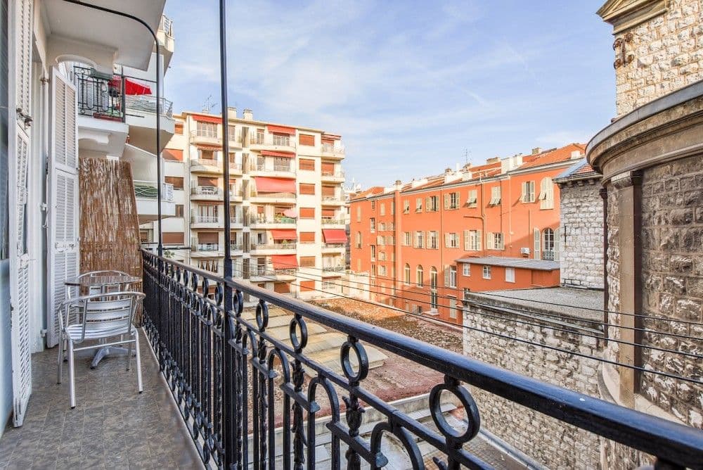 Balcony with wrought-iron railing overlooking the rooftops, 2-bedroom apartment in the Carré d’Or, Nice