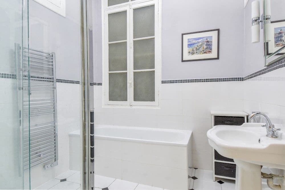 Bathroom with bathtub, glass shower screen and pedestal basin, 2-bedroom apartment in the Carré d’Or, Nice