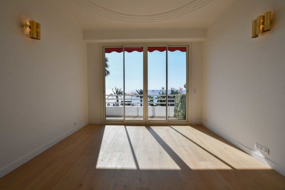Living room with oak floor and sliding doors to a sea-view balcony, 3-bedroom apartment in the Promenade des Anglais, Nice