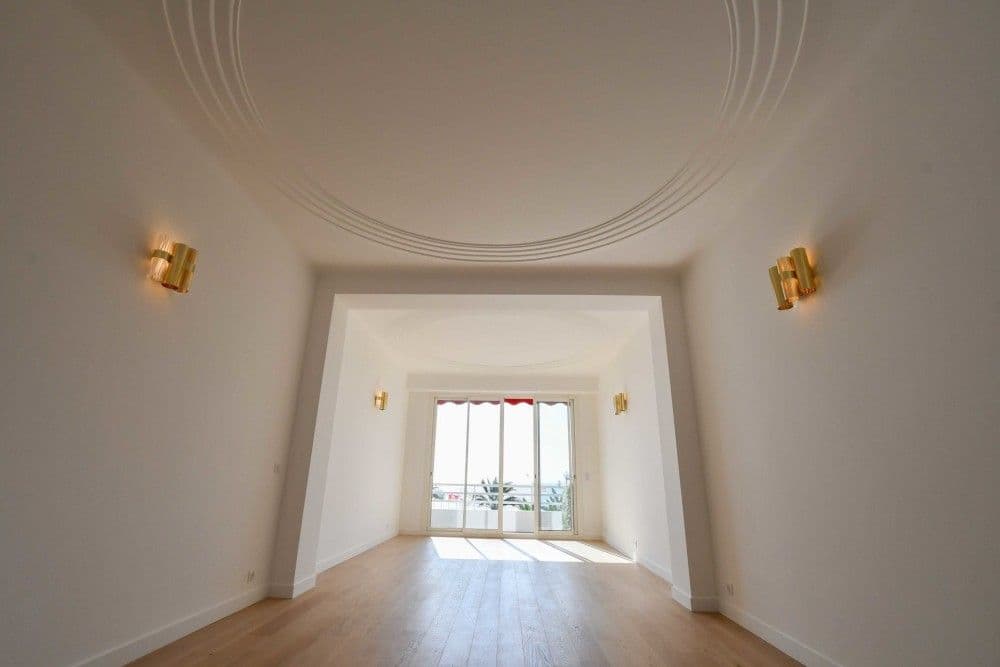 Renovated living room with moulded ceiling and doors to the balcony, 3-bedroom apartment in the Promenade des Anglais, Nice