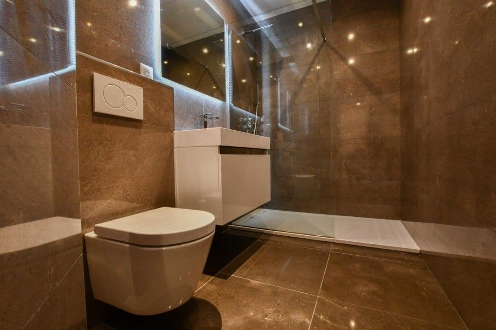 Shower room with brown stone tiles, walk-in shower and wall-hung toilet, 3-bedroom apartment in the Promenade des Anglais, Nice
