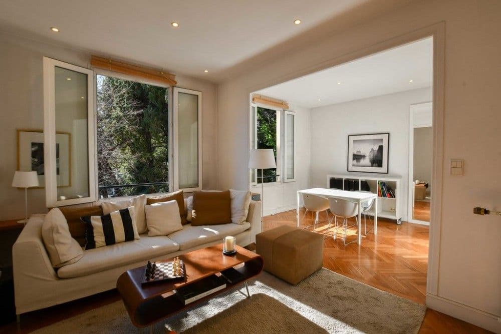 Living room with herringbone parquet and windows onto trees, 1-bedroom apartment in the Port, Nice