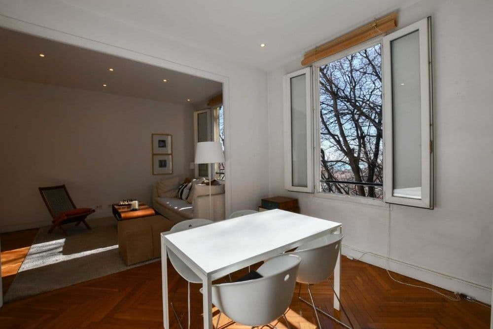 Dining area with white table and window overlooking trees, 1-bedroom apartment in the Port, Nice