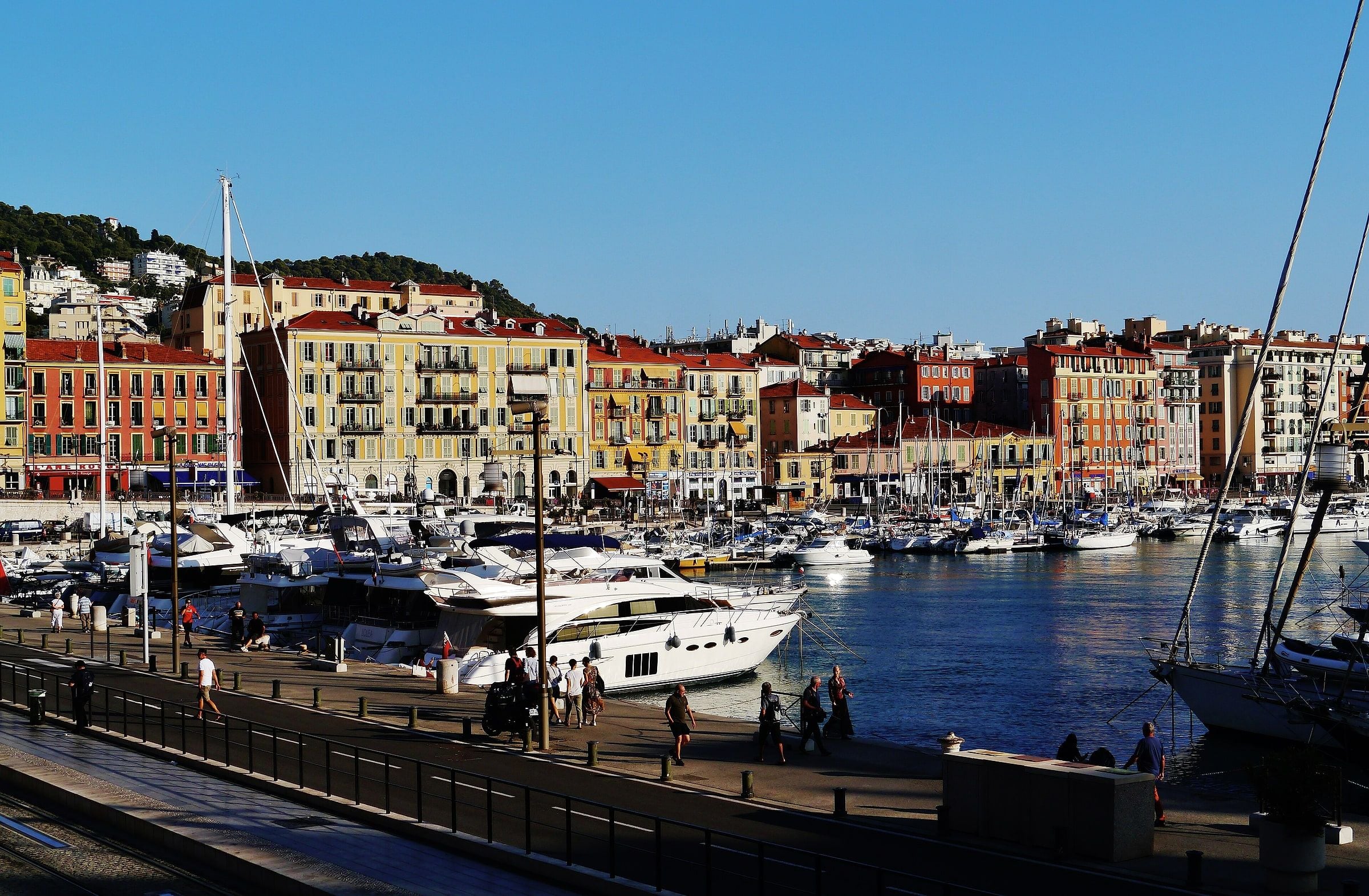 Boats in Port Lympia in front of the ochre façades around the harbour