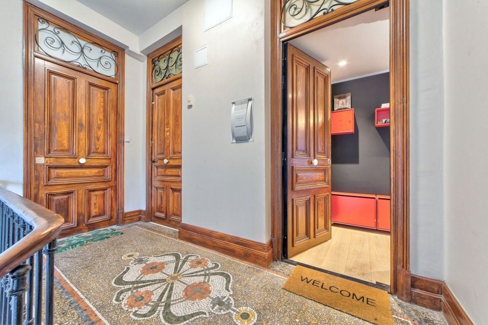 Landing with terrazzo floor and the apartment’s carved wooden door, 2-bedroom apartment in the Port, Nice
