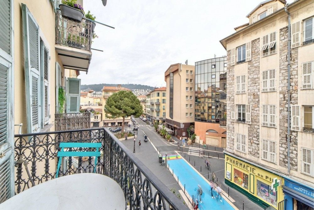 Balcony with wrought-iron railing overlooking a pedestrian street in the Port, 1-bedroom apartment in the Port, Nice
