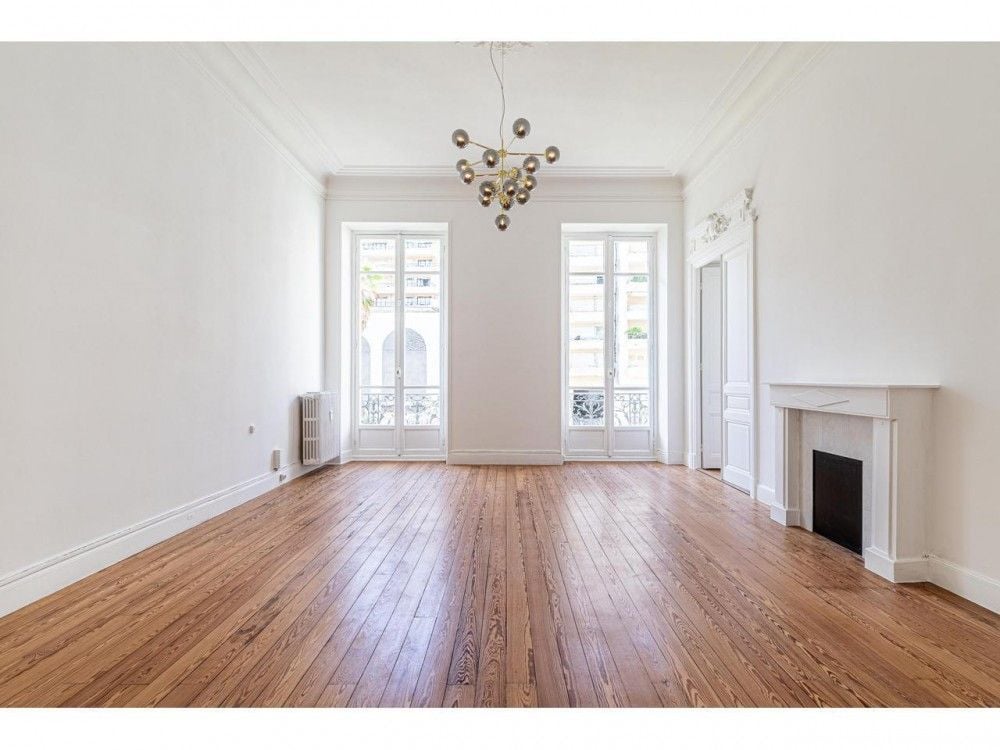 Reception room with chandelier, marble fireplace and parquet floor, 3-bedroom apartment in the Carré d’Or, Nice