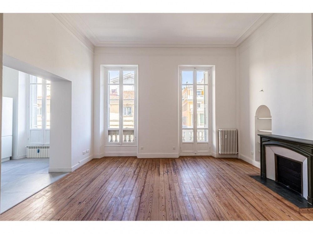 Room with black marble fireplace and parquet floor, 3-bedroom apartment in the Carré d’Or, Nice
