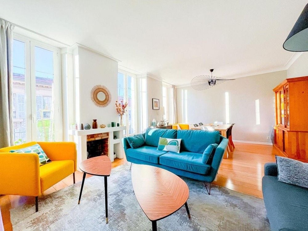 Living room with fireplace, blue sofa and yellow armchair, 2-bedroom apartment in central Nice