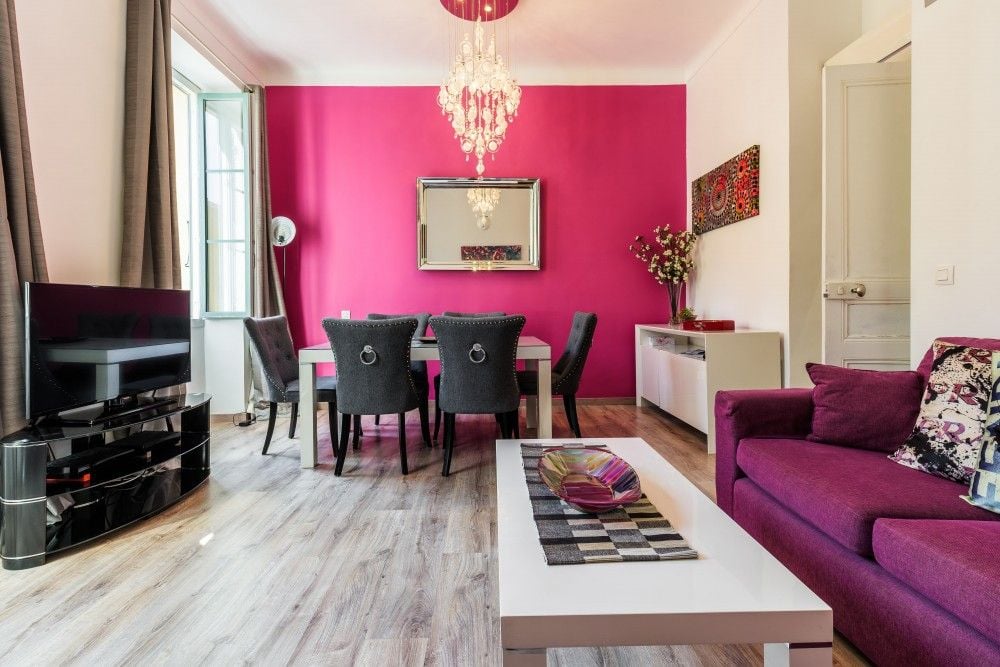 Living room with purple sofa, dining table and pink feature wall, 2-bedroom apartment in the Port, Nice
