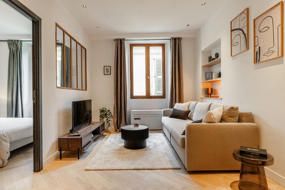 Living room with sofa, glass partition and window, 2-bedroom apartment in the Old Town, Nice
