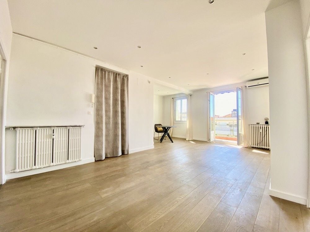 Living room with wooden floor and French windows, 2-bedroom apartment in the Carré d’Or, Nice