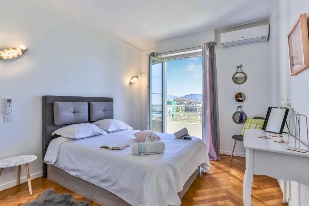 Bedroom with parquet floor and doors to the balcony, 2-bedroom apartment in the Promenade des Anglais, Nice