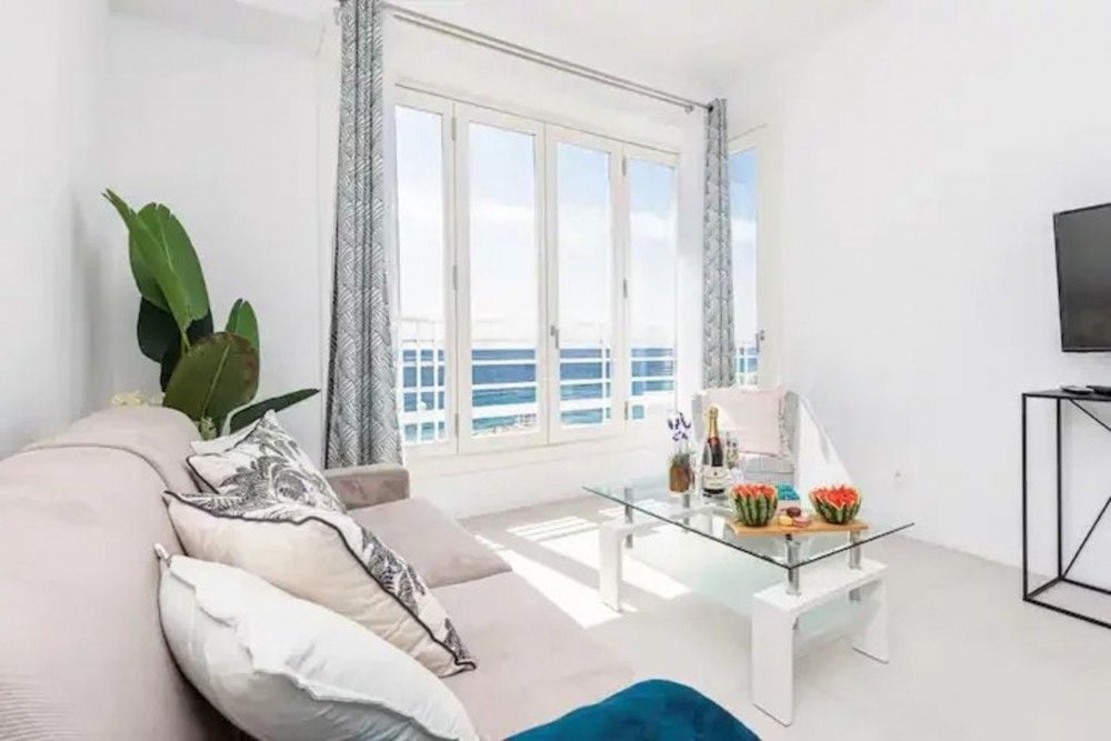 Living room with sofa, glass coffee table and windows facing the sea, 2-bedroom apartment in the Promenade des Anglais, Nice