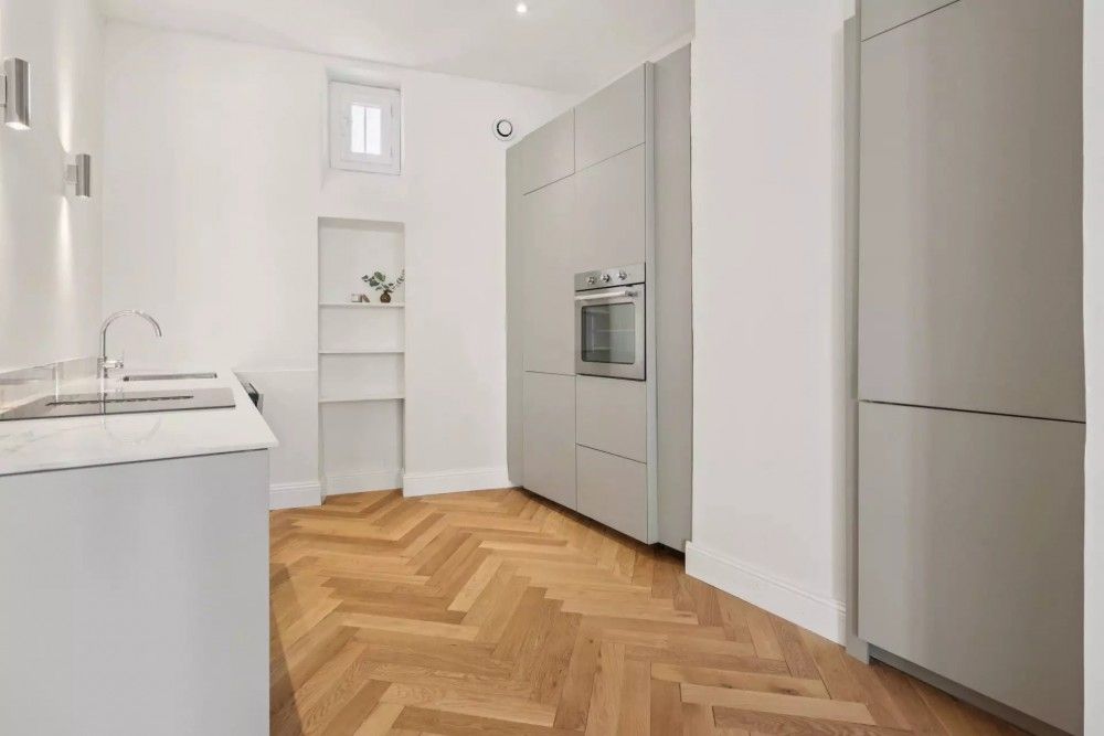 Kitchen with grey handleless units and herringbone parquet, 2-bedroom apartment in central Nice