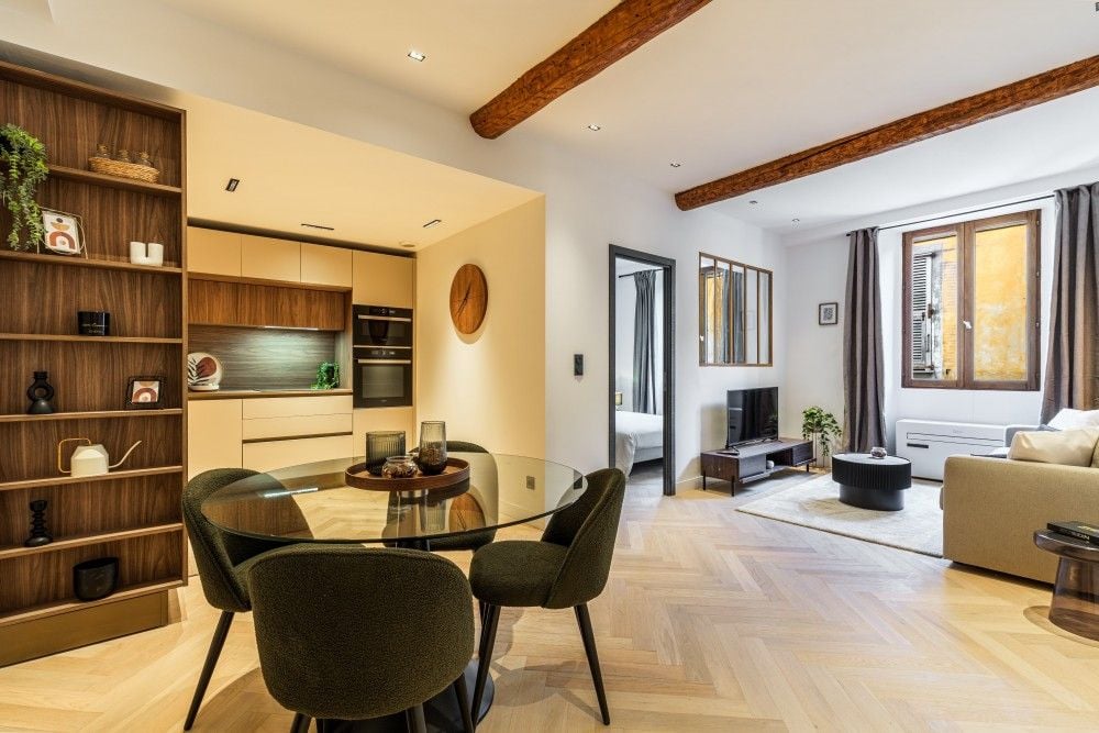 Renovated open-plan living room with exposed beams and herringbone floor, 2-bedroom apartment in the Old Town, Nice
