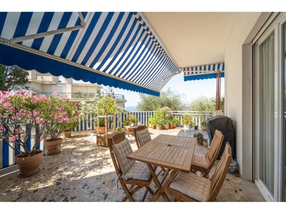 Covered terrace with dining table and flowering plants, 2-bedroom apartment in Mont Boron, Nice