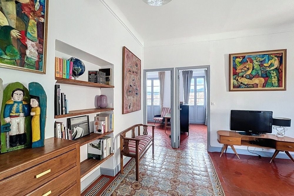 Living room with bookshelves and patterned cement tiles, 3-bedroom apartment in the Old Town, Nice