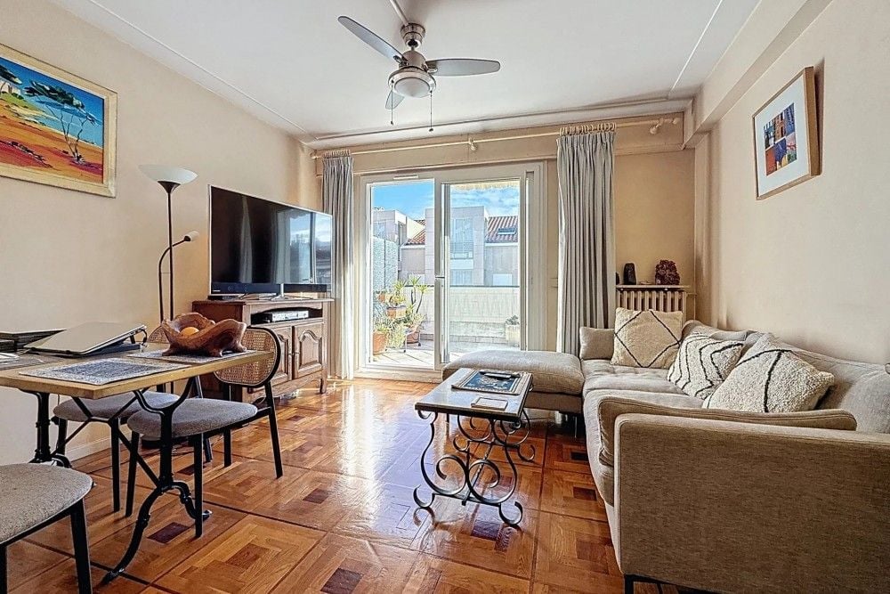 Living room with parquet floor, sofa and doors to the terrace, 1-bedroom apartment in the Musicians’ Quarter, Nice