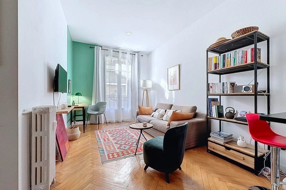 Living room with herringbone parquet, bookshelf and green feature wall, 1-bedroom apartment in the Port, Nice