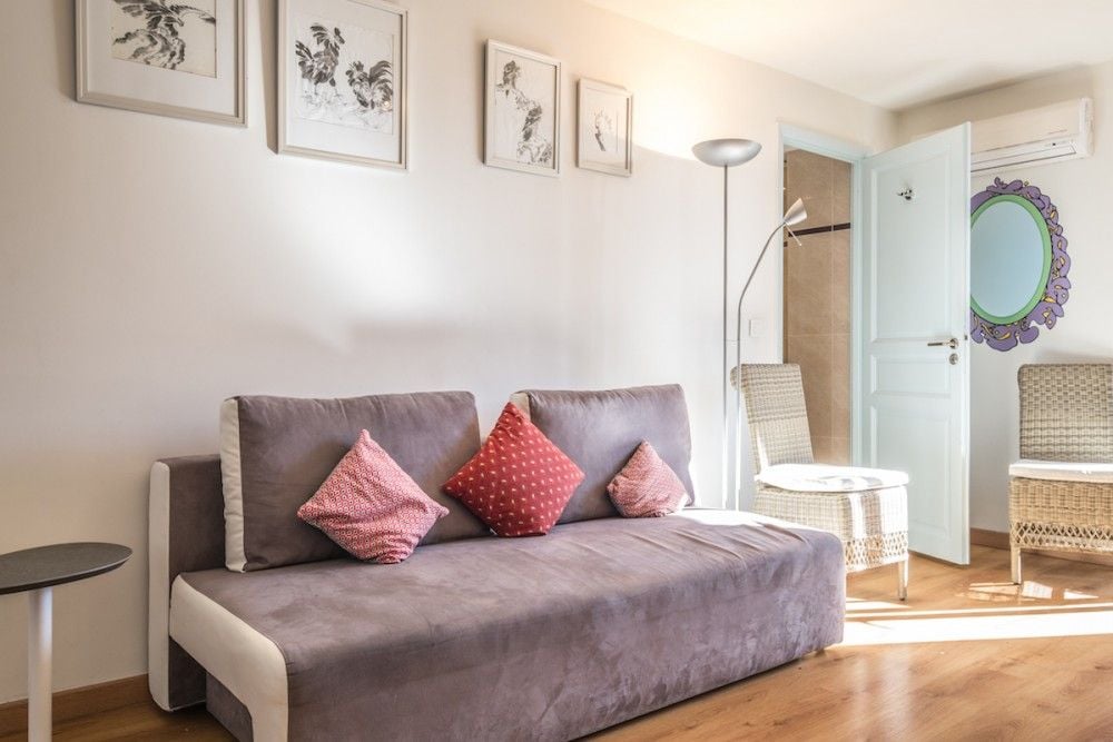 Living room with sofa bed and wooden floor, 1-bedroom apartment in the Carré d’Or, Nice