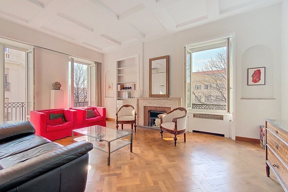 Living room with marble fireplace, parquet floor and tall windows, 3-bedroom apartment in central Nice